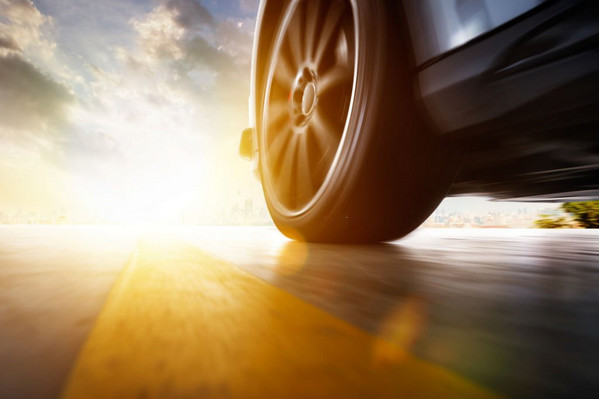 low-angle-side-view-of-car-driving-fast-at-sunset-with-motion-speed-effect
